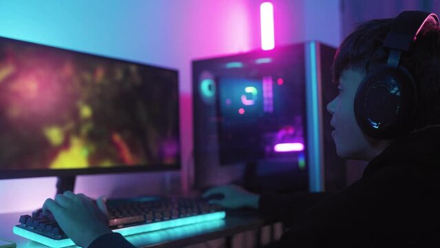 Teenager playing strategy video game online inside gaming room. E-sport, technolgy concept