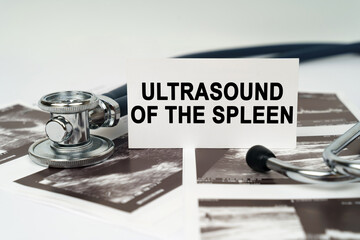 On the ultrasound pictures there is a stethoscope and a business card with the inscription - Ultrasound of the spleen