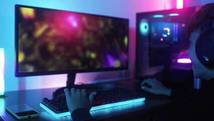 Young gamer playing e-sport video game competition online inside gaming room. Multiplayer, gaming technology concept