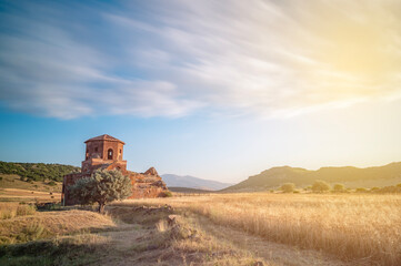 Fototapeta na wymiar Red church ruins in Nigde province, sunset colors and clouds in the sky and sun light