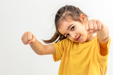 Little Caucasian girl driving invisible car isolated on white background.