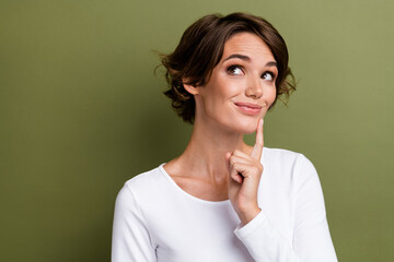 Photo of adorable business lady looking empty space overthinking wearing white casual pullover isolated khaki green color background