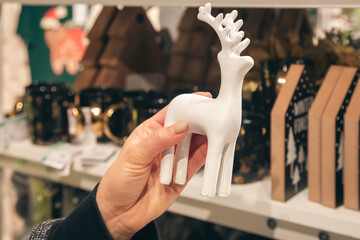 Decorative statue of a deer in female hands in a store.