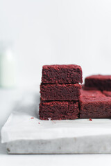 Thick red velvet brownies on a white tray, red velvet fudge brownies on a white background, homemade red brownies for valentines day