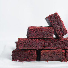 Fudgy red velvet brownies on a white marble tray, red velvet fudge brownies on a white background,...