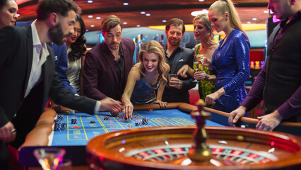 Footage of a Spinning Roulette Wheel. Female and Male Guests Placing Risky Bets while Playing Roulette. Crowd Celebrating a Positive Outcome and Cheering the Winners