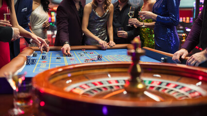 Anonymous Group of Elegant Casino Guests Placing Bets on a Table. Close Up Footage of a Spinning...