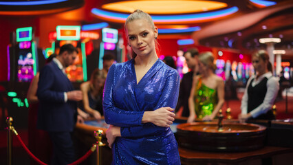In a Modern Casino Setting: Gorgeous Caucasian Blond Woman Posing Confidently, Looking at Camera,...