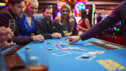 Diverse Group of Glamorous People Playing Game of Blackjack with Professional Female Croupier...