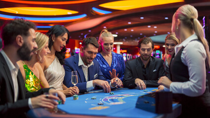 Group of Casino Goers Enjoying Time in a Modern Casino, Friends Placing Blackjack Bets, Professional Female Croupier Deals Cards. Diverse Group People Playing, Placing Bets Winning and Celebrating - obrazy, fototapety, plakaty