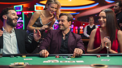 Group of Gorgeous Multiethnic Men and Women Playing in a Game of Poker in Joyful Casino. Glamorous...