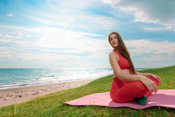 Fototapeta na wymiar Attractive athletic young girl sitting sport mat by the sea, Sportswear calm: A young woman unwinds by the sea, embracing relaxation on the shore