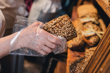 Brot wird von Verkäuferin aus dem Regal genommen