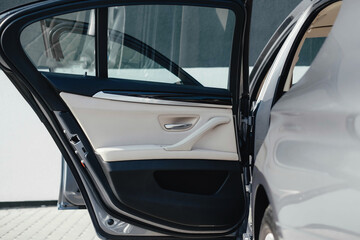 Interior of a business-class car, white perforated leather, aluminum, black lacquer, interior details.