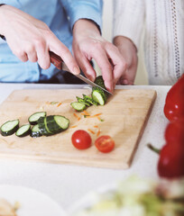 Closeup of hands of a woman cooking vegetables salad