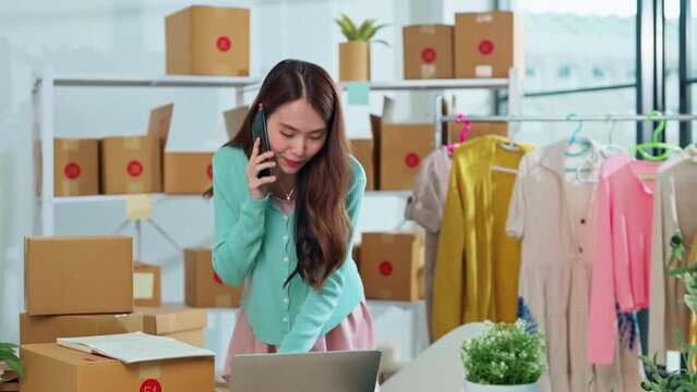 small business fashion store shop onwer discuss checking business order contract deal at home while conversation on smartphone and checking cloth inventory and order checking for make sure 