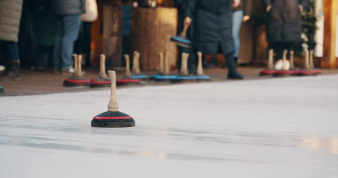 Curling with wooden ice stock curling stone game in the winter time
