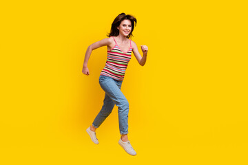 Full size photo of energetic gorgeous woman dressed knit top jeans run shopping to empty space isolated on yellow color background