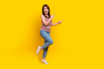 Fototapeta na wymiar Full body photo of impressed girl wear striped tank hold arms folded indicating at sale empty space isolated on yellow color background