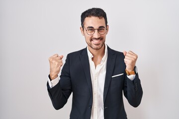 Handsome business hispanic man standing over white background celebrating surprised and amazed for...