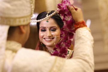 Closuep of beautiful bride smilling at garland ritual, indian wedding