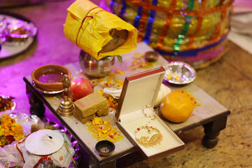 Gold nath and sweets on pooja at indian wedding event