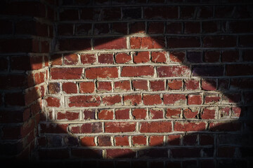 mur de brique éclairé par une fenêtre de toit