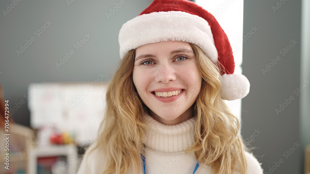 Sticker young blonde woman preschool teacher wearing christmas hat standing at kindergarten