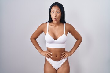 Fototapeta premium Hispanic woman wearing lingerie afraid and shocked with surprise and amazed expression, fear and excited face.