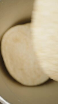 Vertical video. View from inside the can with saddle-shaped chips. I take one piece while the camera zooms out of the can. Dolly slider, close up.