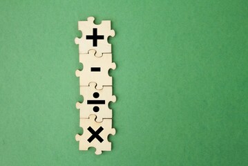 wooden puzzle with plus, minus, division and multiplication signs. mathematics learning concept