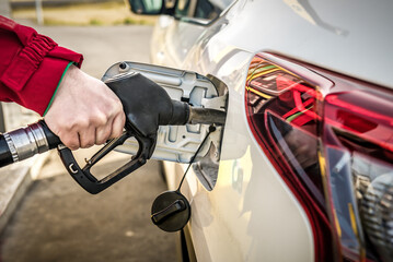 Car fueling at gas station. Refuel fill up with petrol gasoline. Petrol pump filling fuel nozzle in...