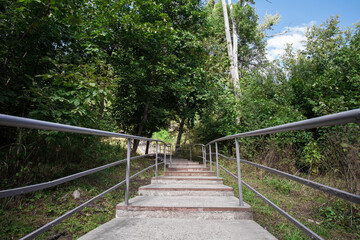 Picturesque staircase with iron railings in the city park. Image for your creative design or illustrations about nature and leisure.