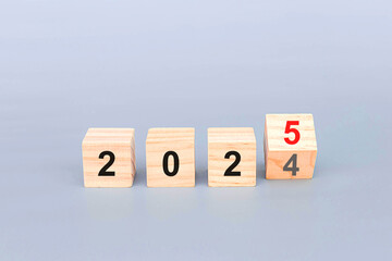 Flipping of 2024 to 2025 on wooden block cube for preparation new year change and start new...