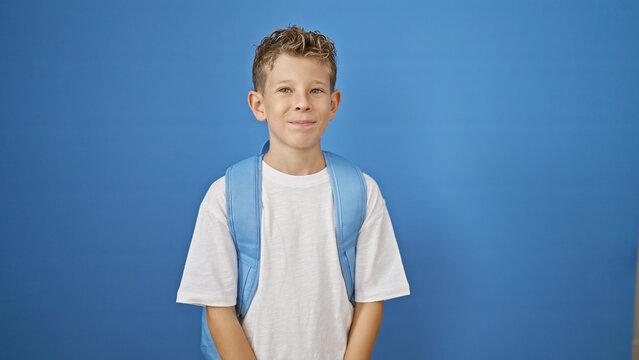 Blond boy student smiling confident over isolated blue background