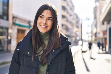 Young beautiful hispanic woman smiling confident looking to the side at street