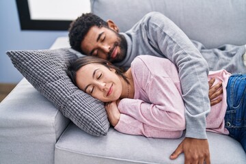 Man and woman couple lying on sofa sleeping at home
