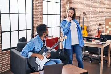 Man and woman musicians having online violin lesson at music studio