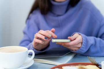 Business woman using mobile device at brunch time