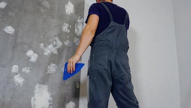 A man glues wallpaper on the floor in a room, Time lapse