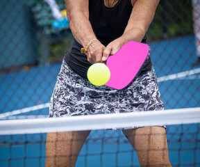 Close up of weoman hitting a two handed backhand during pickleball game