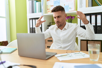 Young hispanic man business worker angry screaming at office