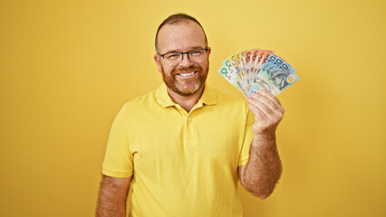 Middle-aged, cheerful caucasian man brandishing australian dollars, exuding confidence against an...