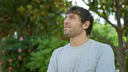 Young man looking to the side with serious expression at the park