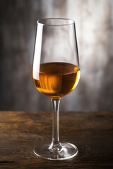 Glass of amber-colored sherry wine on wooden surface