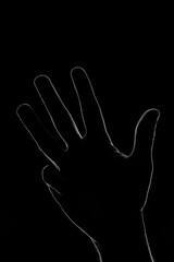 La silhouette de quatre doigts de la main en clair-obscur