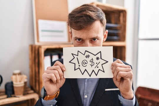Young man business worker holding onomatopeia banner shouting at office