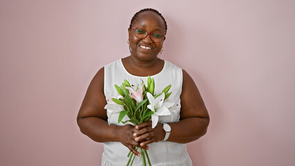 African american woman smiling confident holding bouquet of flowers over isolated pink background
