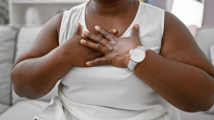 Heartfelt gratitude, overweight african american woman, hands on chest, feeling thankful in her...
