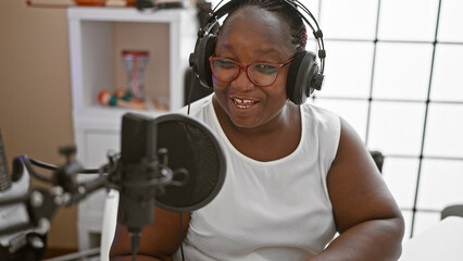 African american woman reporter wearing headphones presenting news at radio studio